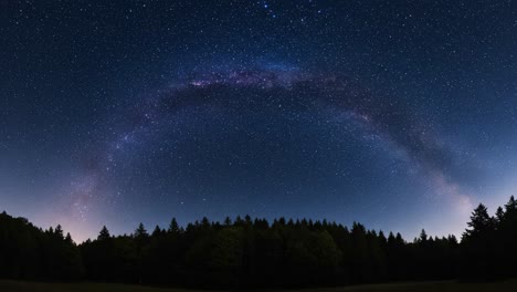 a stunning display of the milky way arching over a serene forest landscape under a starry night sky with twinkling stars in the background