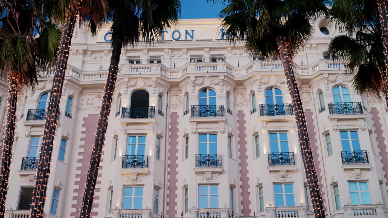 Cannes, France - November 4, 2024: View of palm trees in front of the Carlton Hotel on the coast of the city