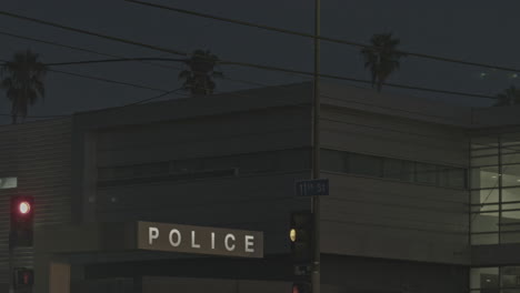 traffic lights and police station at night with palm trees as background