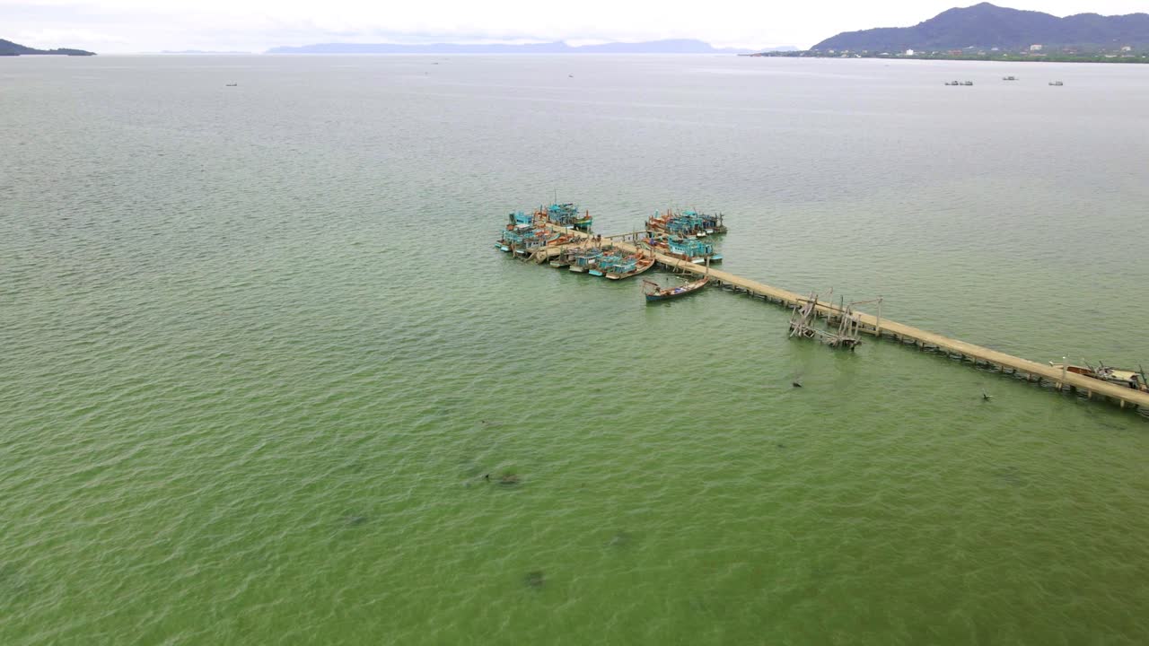 캄보디아 남부 해안의 고요한 에메랄드빛 바닷물에 떠 있는 부두에 정박해 있는 어선