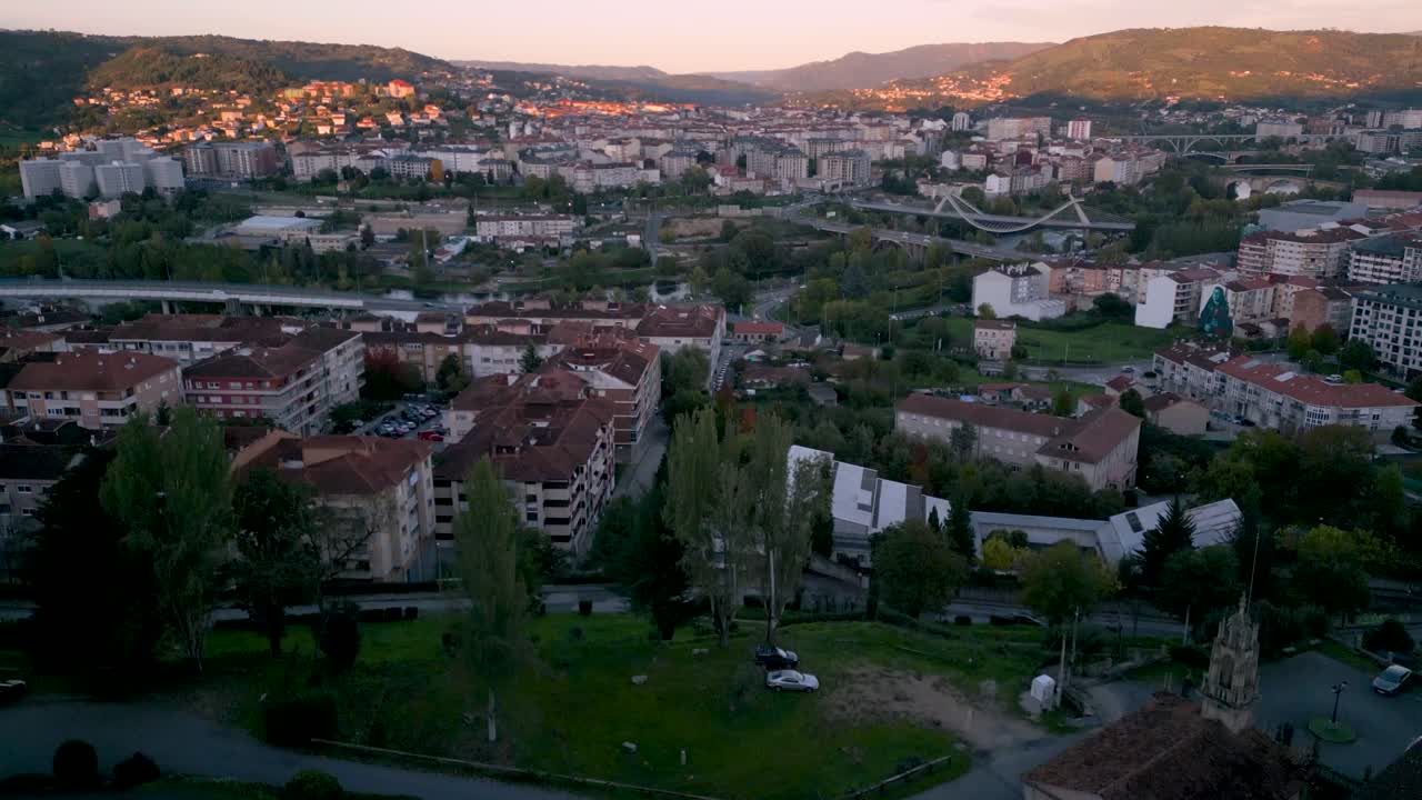 High aerial view of Ourense, Spain at sunset, showing the urban landscape and natural surroundings in soft evening light