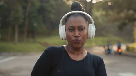 woman with headphones exercising in park