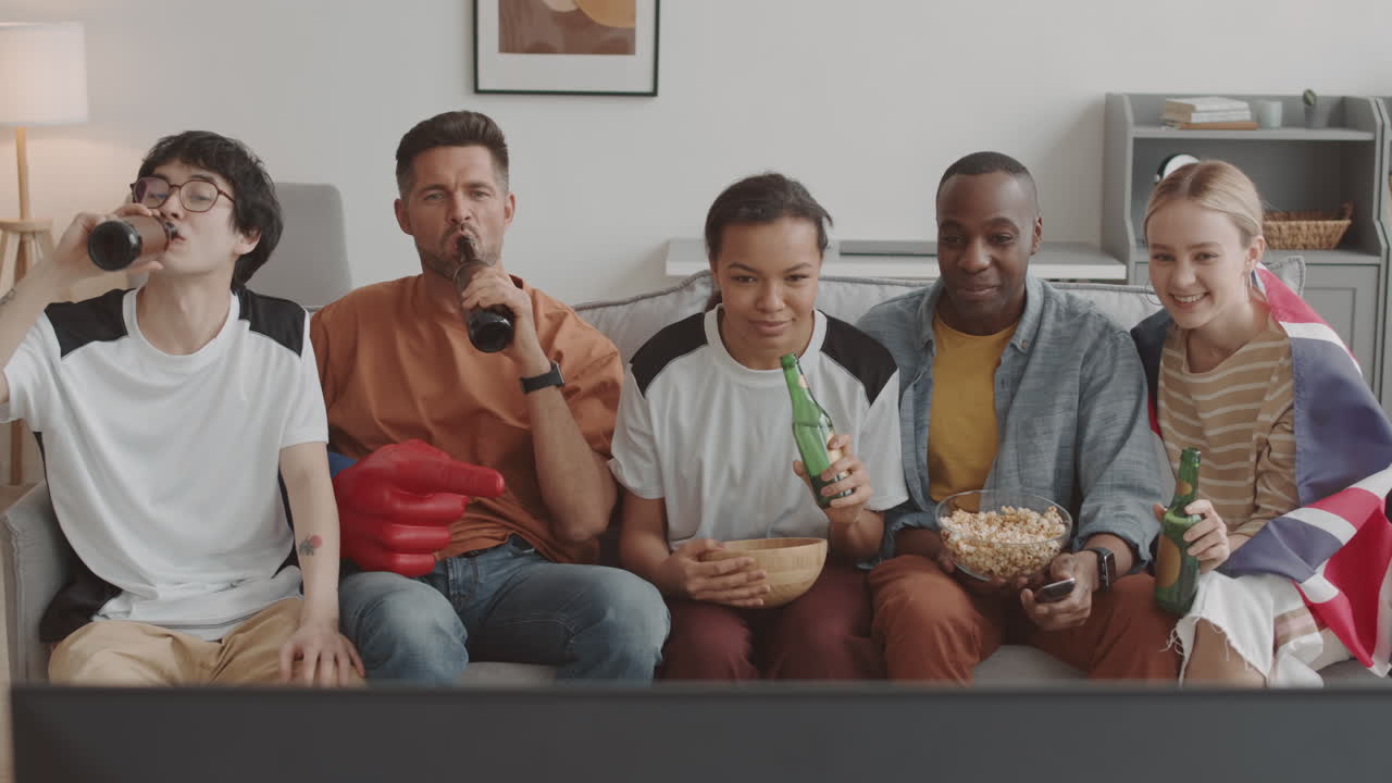 Friends Clinking Beer Bottles on Couch
