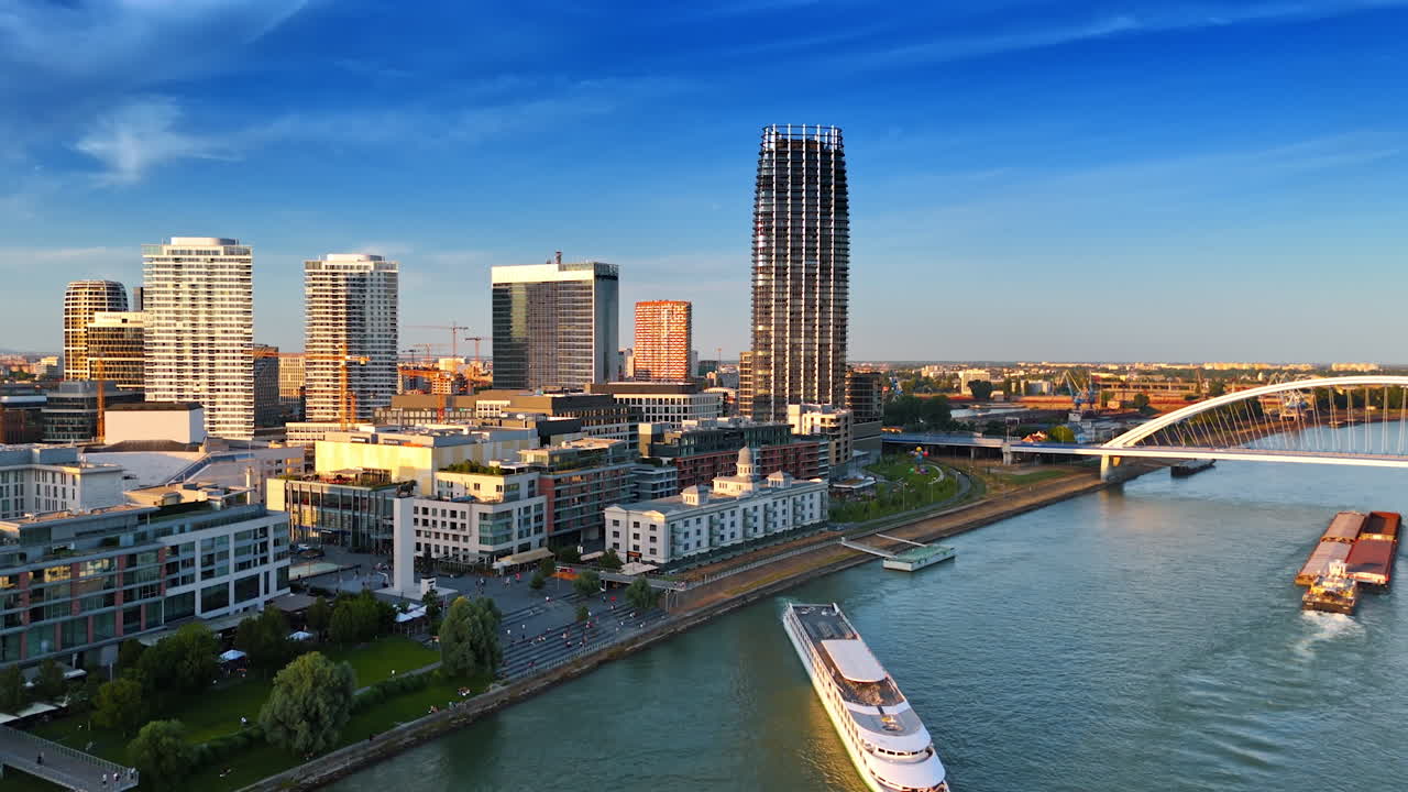 Bratislava, Slovakia, 2 June 2025: Bratislava sunset skyline view. A boat glides along the Danube River as the Bratislava skyline glows under a vibrant sunset