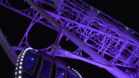 the beautiful purple glow of a ferris wheel in granada, spain - tilt up