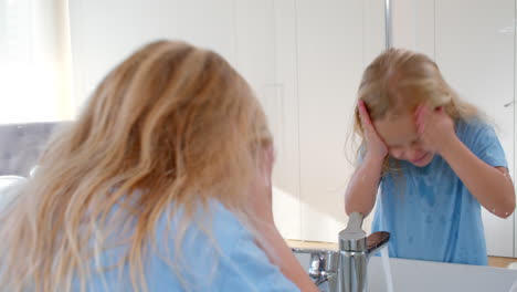 girl washing face in sink