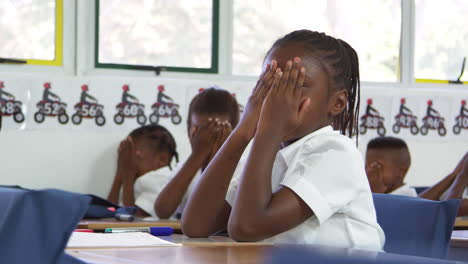 schoolgirl with head in hands at lesson at elementary school