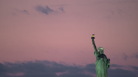 estatua de la libertad con luces encendidas y cielo rosado