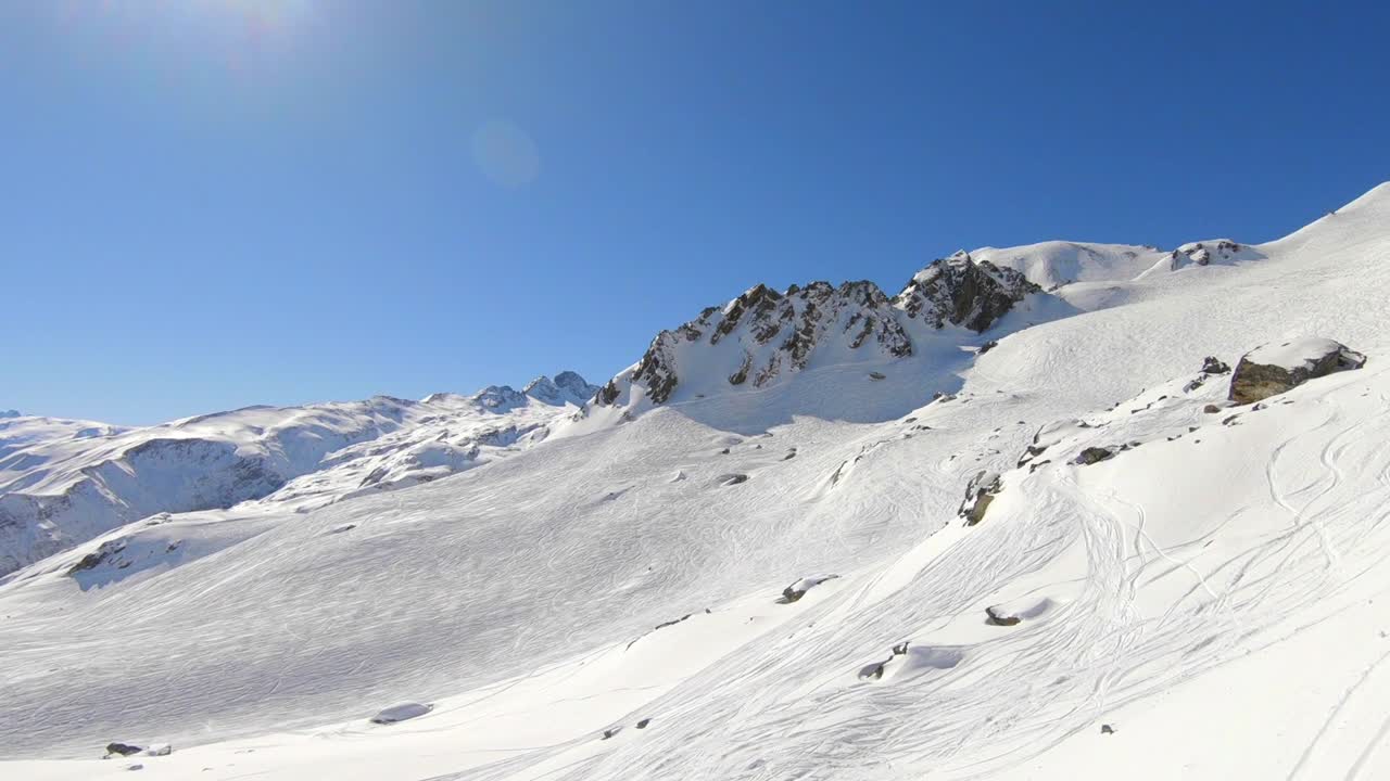 toma aérea sobre la ladera de una montaña cubierta de nieve, con hermosas formaciones rocosas