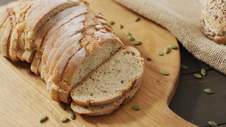 Video of bread on chopping wooden board on wooden worktop