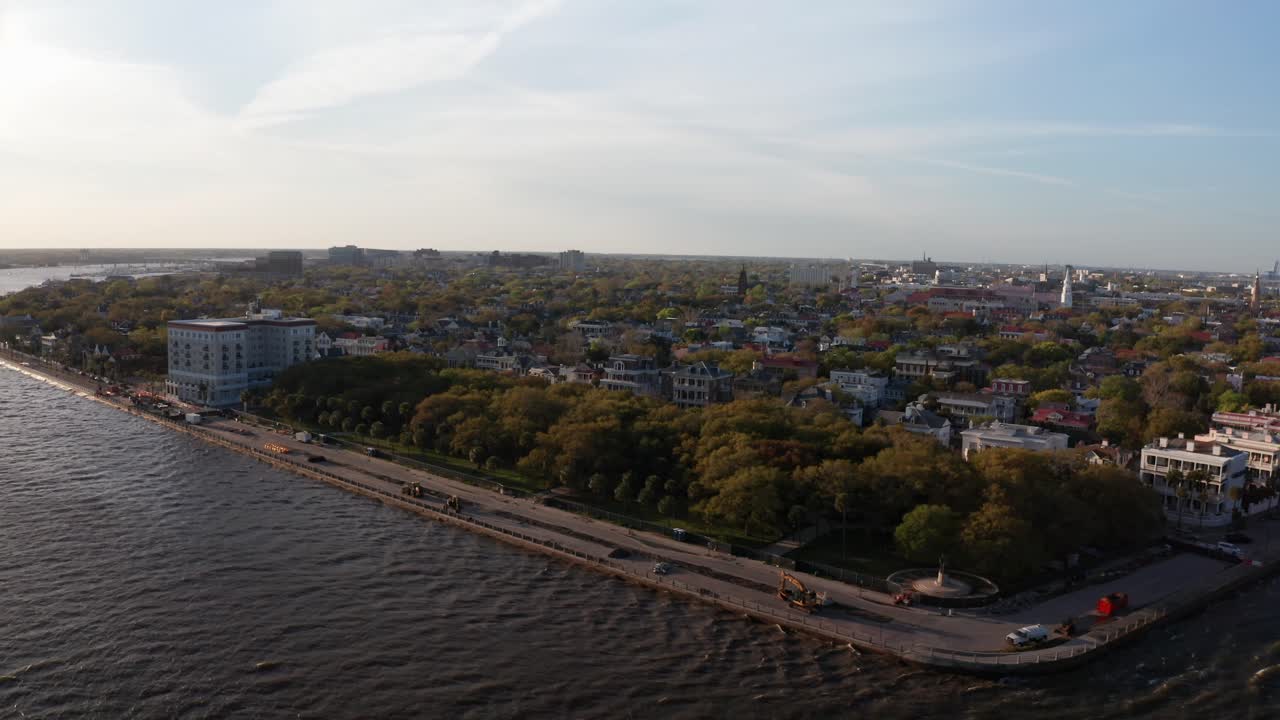 Tomada aérea em dolly e panorâmica do White Point Garden ao longo do paredão South Battery durante o pôr do sol em Charleston, Carolina do Sul