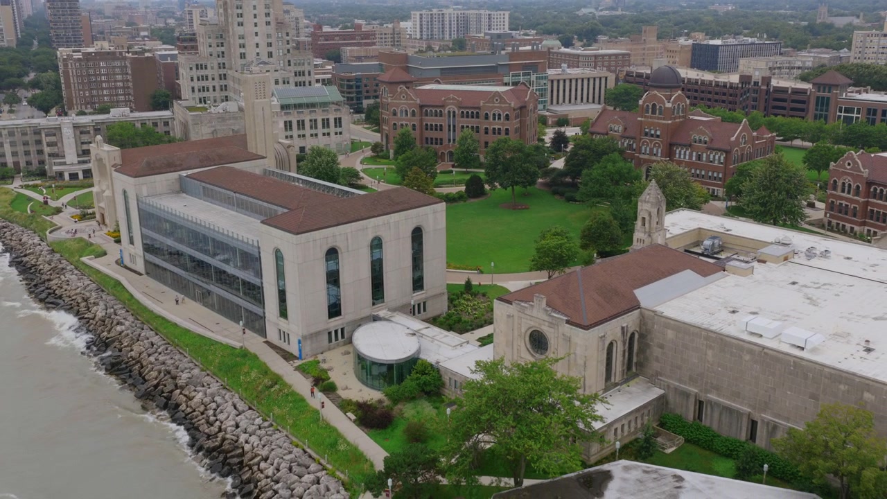 Vista aerea con drone di un cortile universitario a Chicago, con edifici gotici e romanici attorno a un prato verde