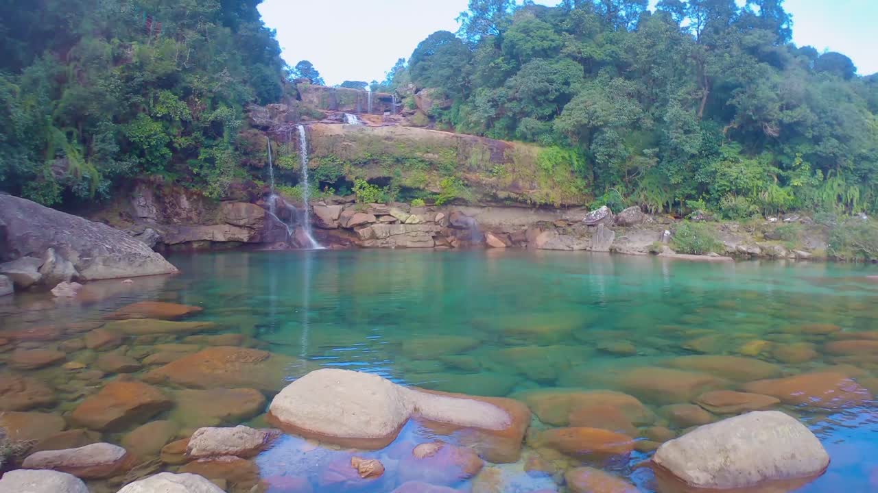 cascada natural que cae desde la cima de la montaña con un cielo azul espectacular en los bosques