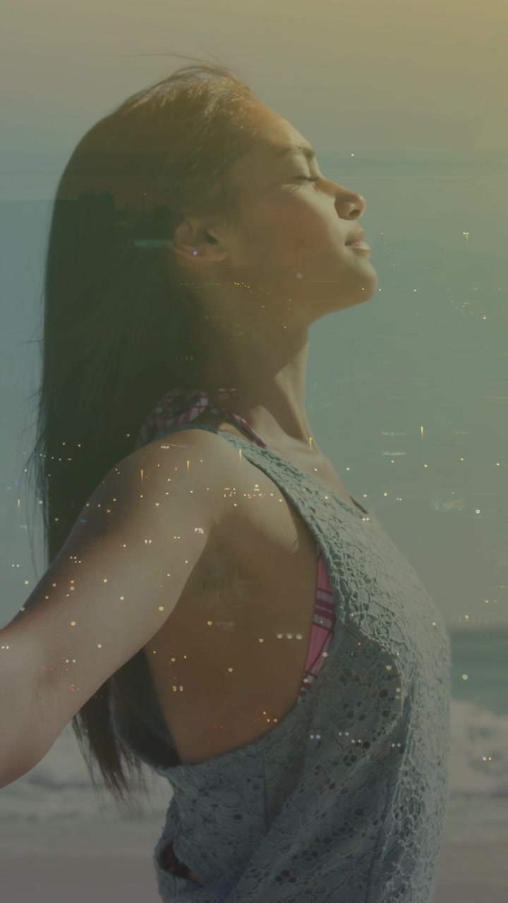 Mujer inhalando en la playa, abriendo los brazos e inclinando la cabeza hacia atrás, con una superposición de grano que resalta el bienestar.