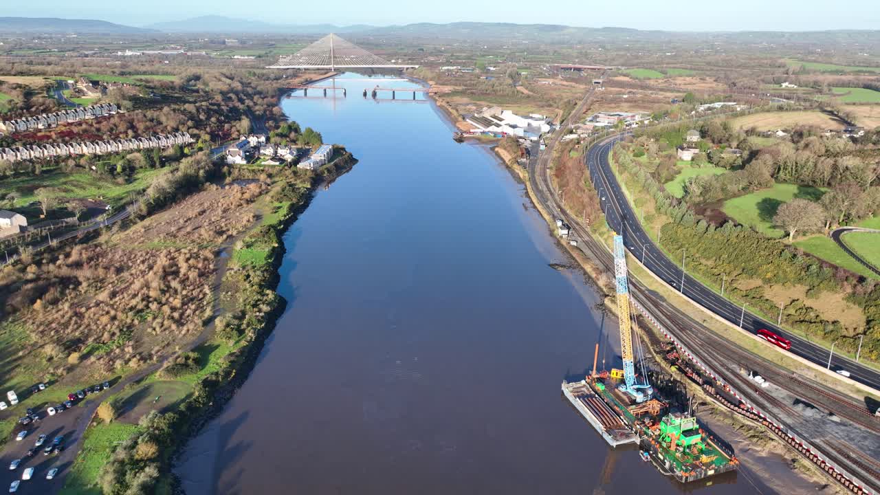 Chiatta di Waterford con riparazioni in corso alla ferrovia e alla strada principale per la città, con ponte di circonvallazione sullo sfondo