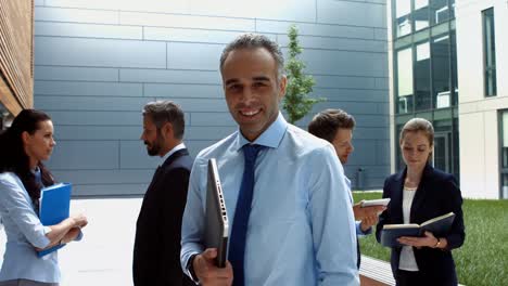 smiling businessman holding laptop