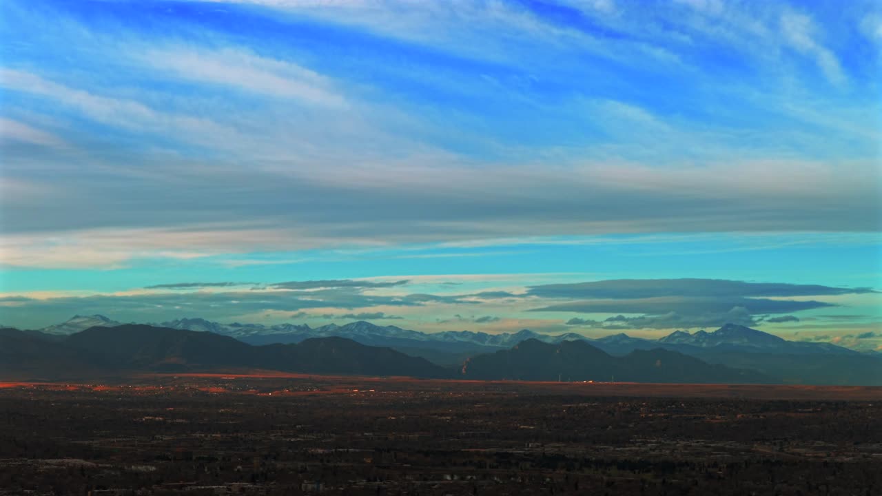 Etualan Kalliovuorten Denverin talvimaisema, panoraamakuva ilmakuvauksesta lennokilla, Boulder Flatirons -vuoret, auringonlaskuiltapäivä, Wheatridge, Arvada, Broomfield, Goldenin lähiöiden esikaupunkialueiden ympyräliike vasemmalle