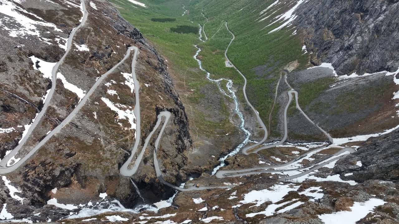 Tilt up aerial from Trollstigen Snowy Peaks and winding roads to Istedalen valley leading to Rauma and Andalsnes - Norway Epic Aerial Journey