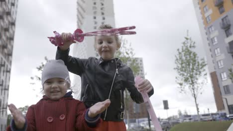 sisters playing with bubbles in the city