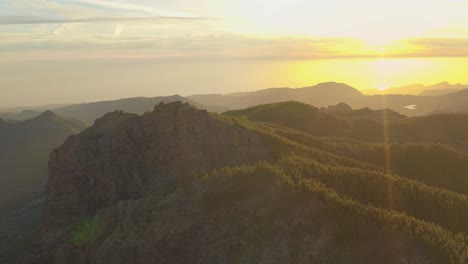 Hermosa-Foto-De-Un-Dron-De-Un-Panorama-De-Montaña-A-La-Hora-Dorada-Con-Un-Bosque-Y-Un-Destello-De-Lente,-Gran-Canaria