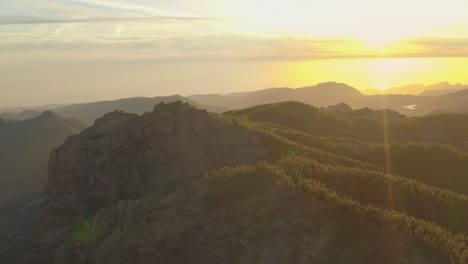 beautiful drone shot of a mountain panorama at golden hour with a forest and lens flare, gran canaria