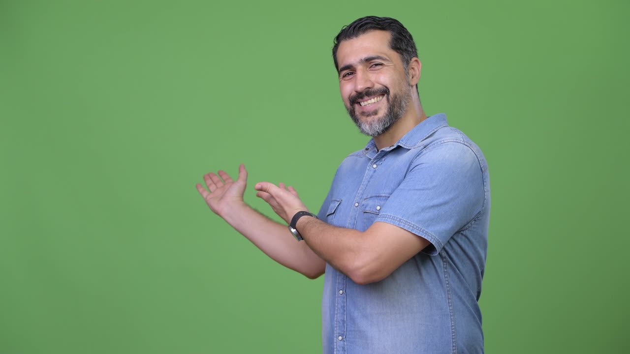 Handsome Persian bearded man showing something