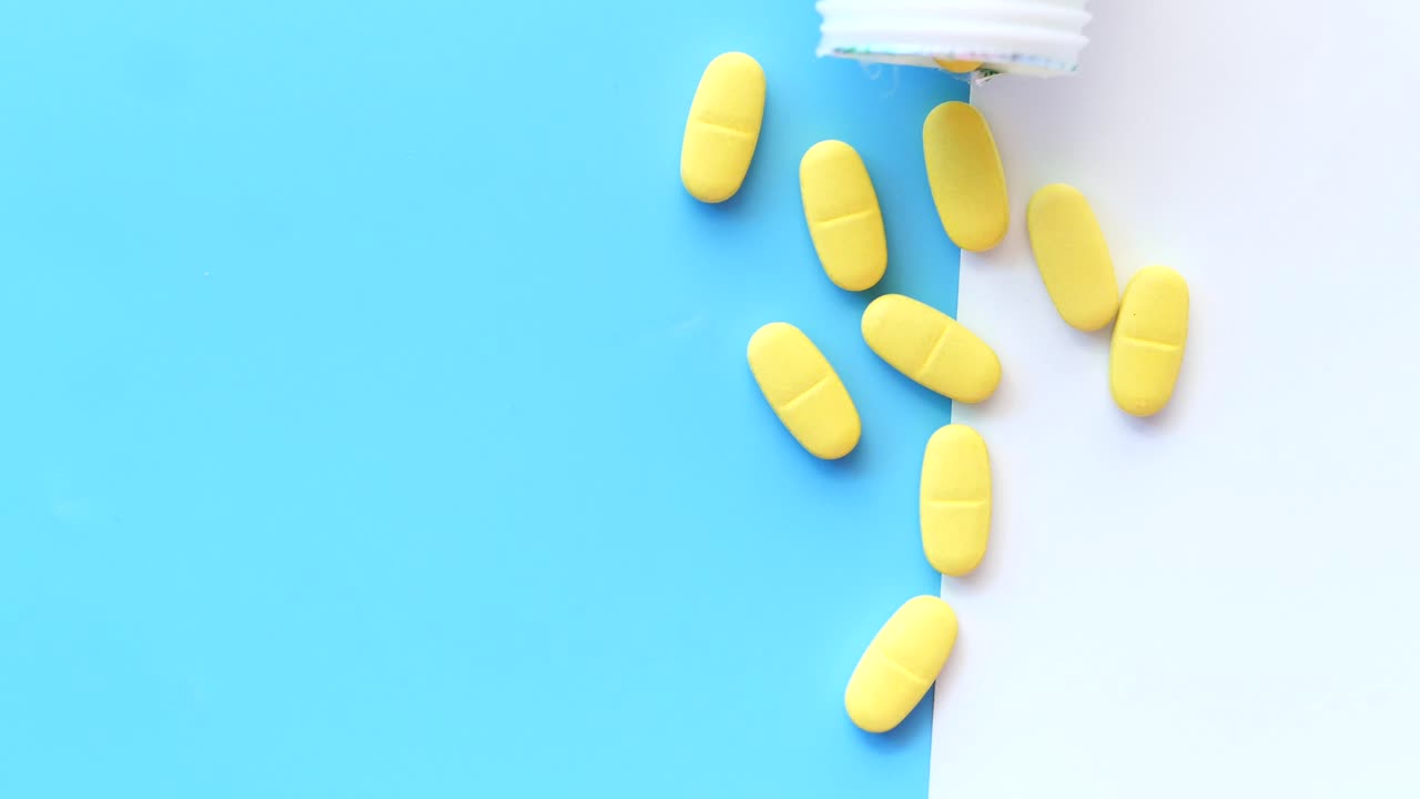 pastillas amarillas derramadas de la botella