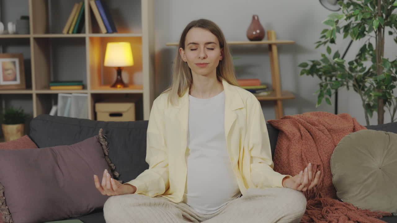 mujer embarazada meditando en casa