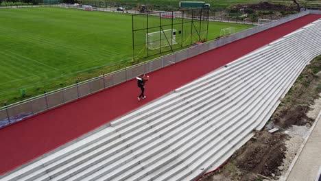 Viajero-Con-Mochila-Caminando-Sobre-Un-Colorido-Campo-De-Fútbol-De-Fondo-Rojo,-Blanco-Y-Verde