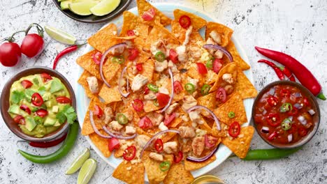 a plate of delicious tortilla nachos with melted cheese sauce  grilled chicken