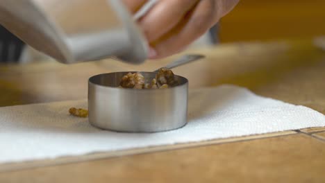 medir media taza de nueces para hacer un desmoronamiento para un pastel de café vegano - aislado