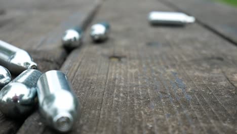 multiple dropping chrome nitrous oxide laughing gas drug cylinders on wooden bench