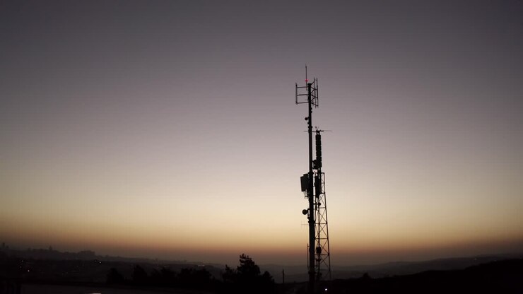 Silhouette di torre di comunicazione al tramonto/all'alba