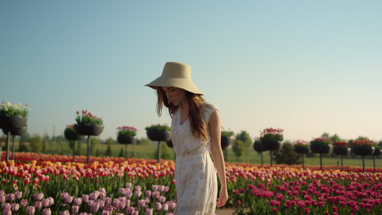 mujer hermosa caminando en el jardín de tulipanes. mujer pasando el tiempo en el campo de flores.