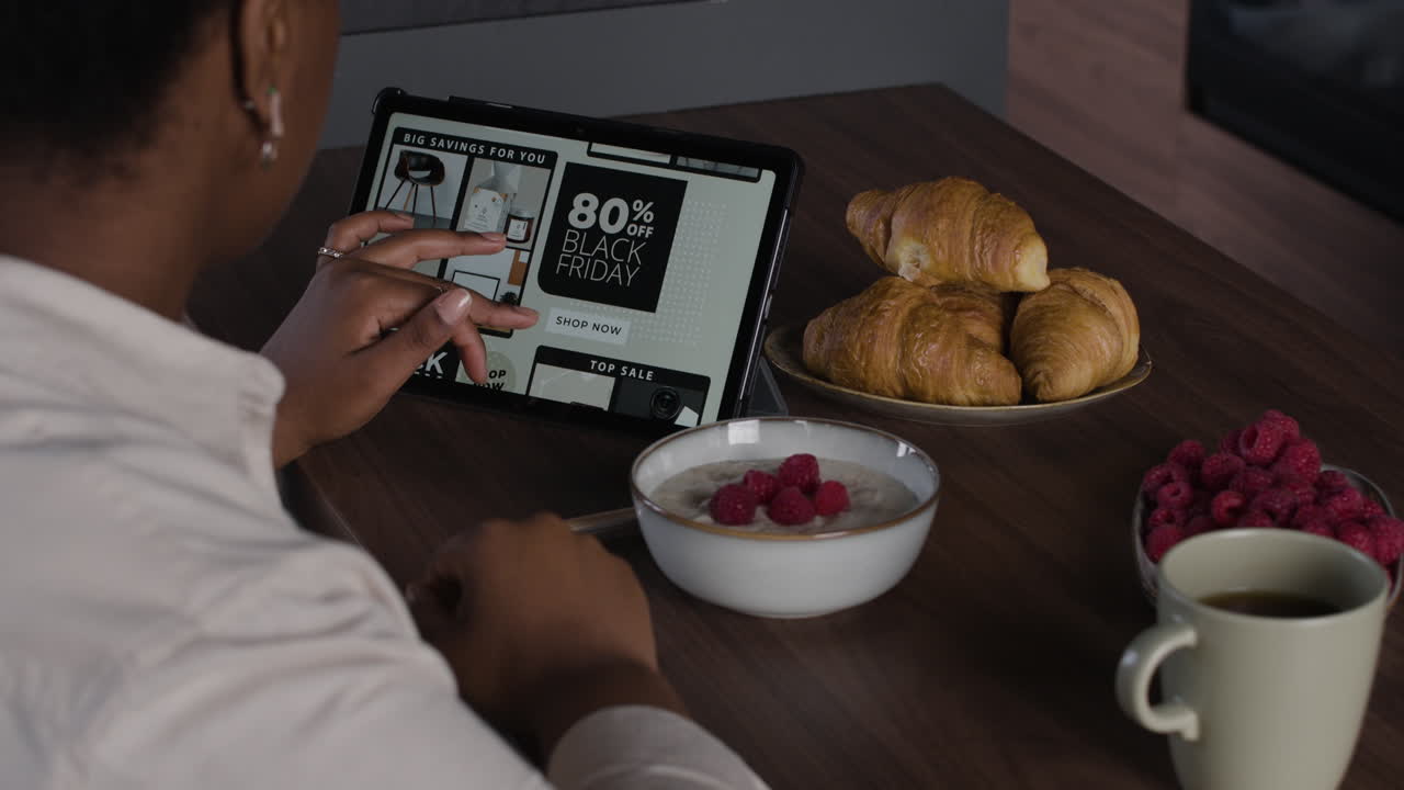 Woman enjoying breakfast while shopping online