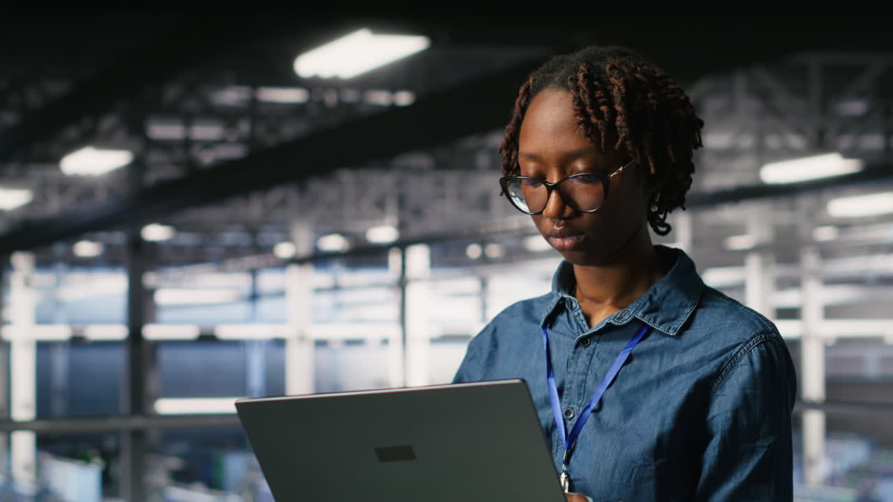Happy woman in data center doing maintenance tasks on laptop
