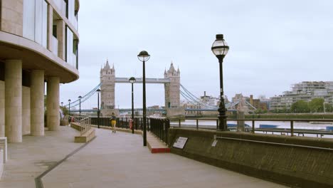 woman running away from camera exercising by tower bridge central london