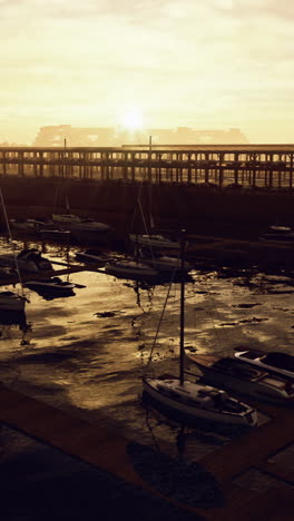 sunset over marina with boats docked at pier during tranquil evening hours