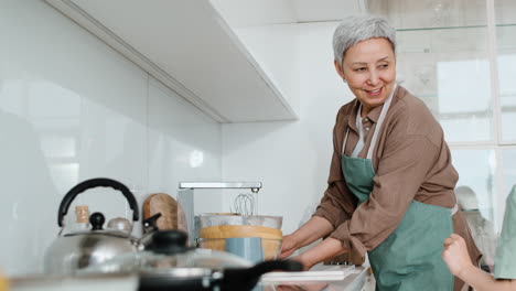 la abuela y la niña haciendo los platos