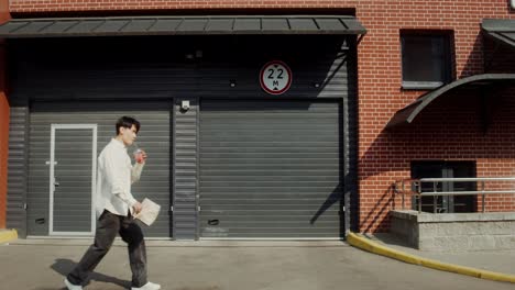 man walking in front of a building with garage doors