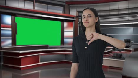 Indian-female-news-anchor-pointing-at-green-screen-and-showing-thumbs-down