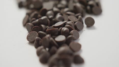 Video-of-close-up-of-multiple-chocolate-chip-over-white-background