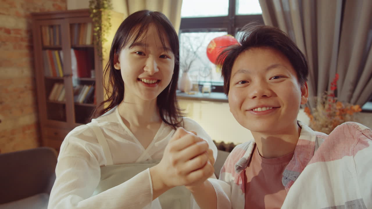 집에서 비디오 통화로 대화하는 두 명의 아시아 여성의 pov