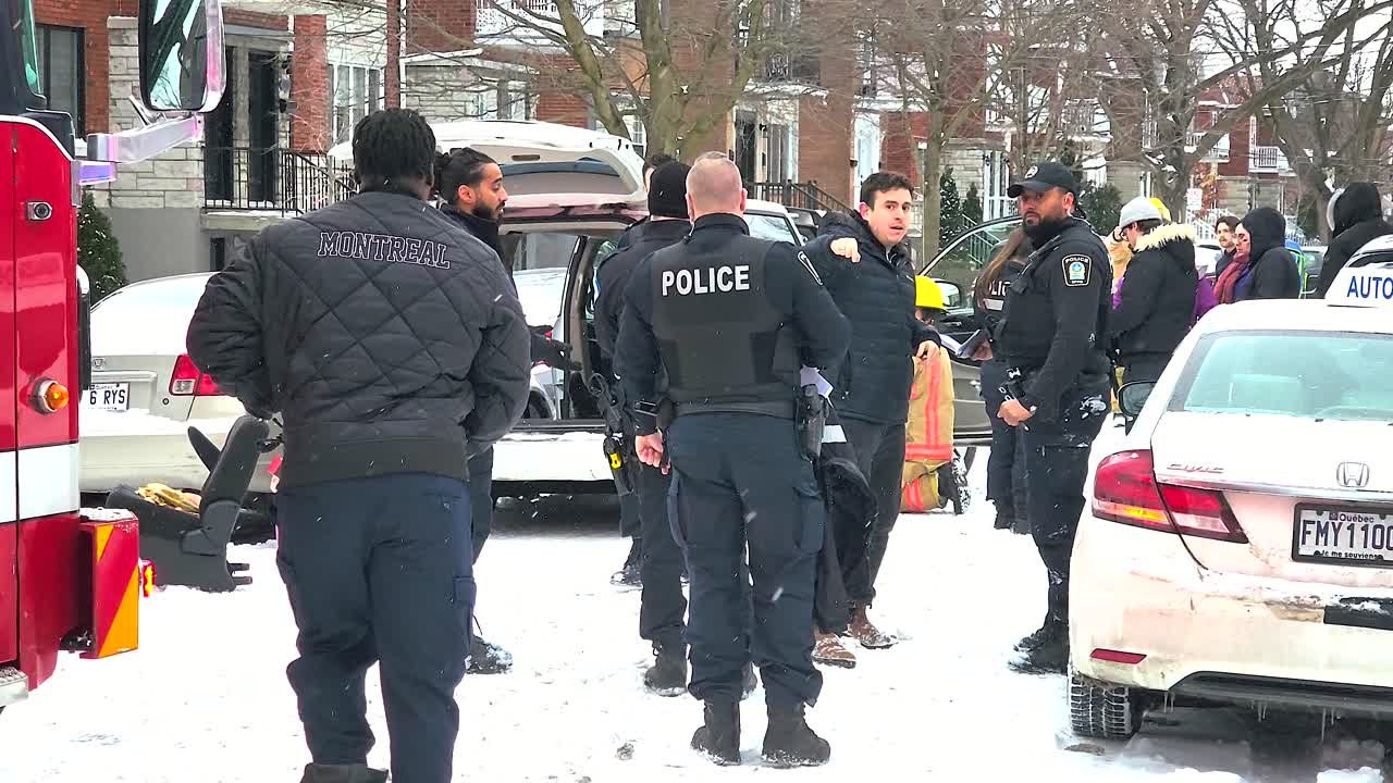 Police officers gathering at the scene of an accident, One of them collecting information from a local Montréal Canada