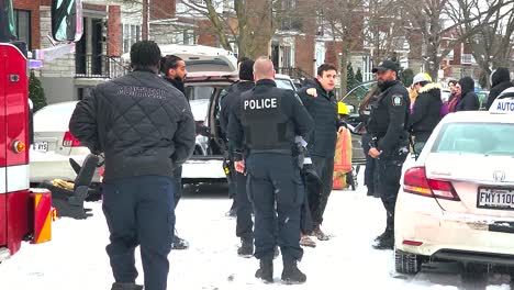 police officers gathering at the scene of an accident, one of them collecting information from a local montréal canada