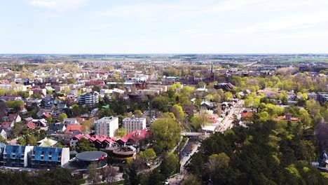 Calm-township-of-Palanga,-with-rooftops-and-church-tower,-aerial-ascend-view