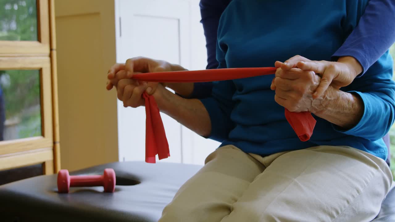 4k 클리닉에서 노인 여성의 자세를 교정하는 물리치료사