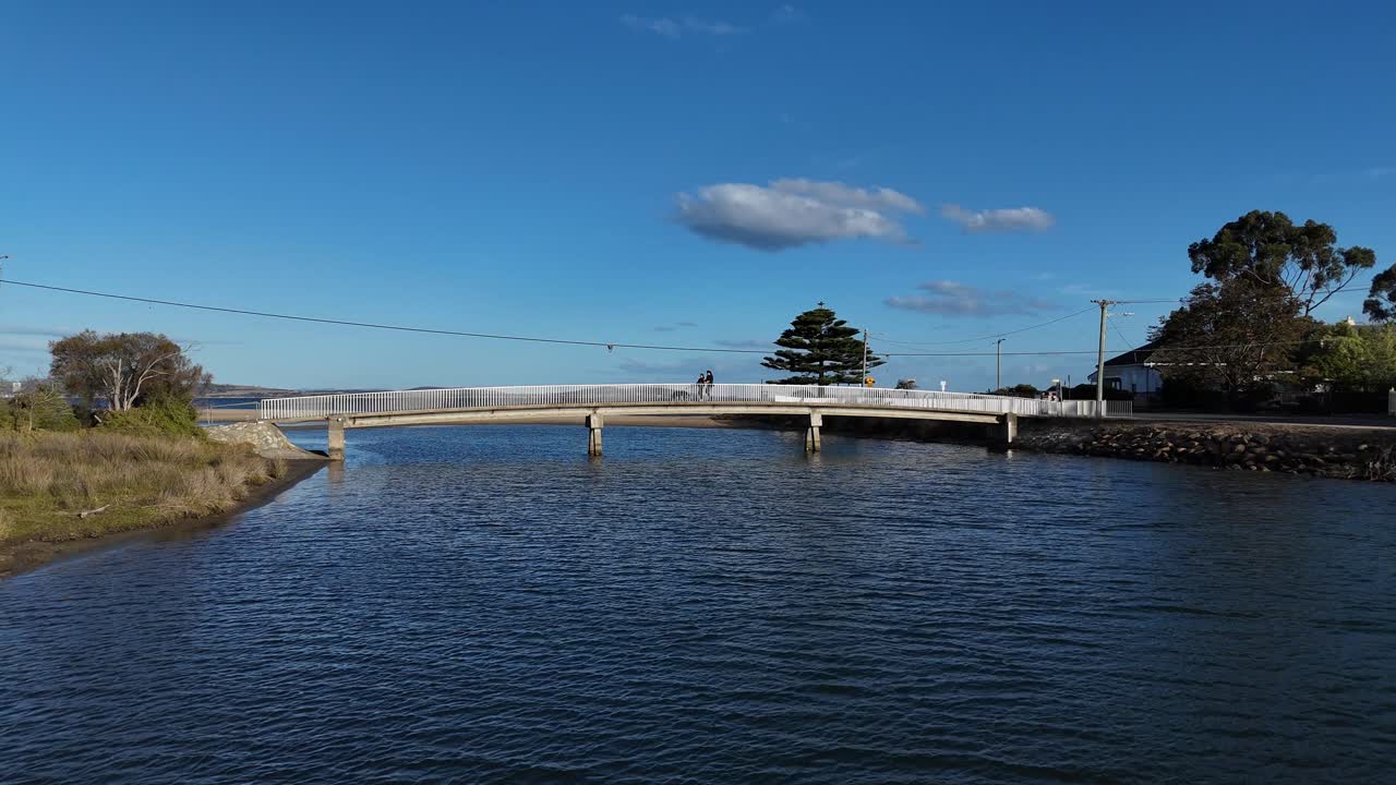 Scenic Bridge Over Calm Ocean Water with People Walking