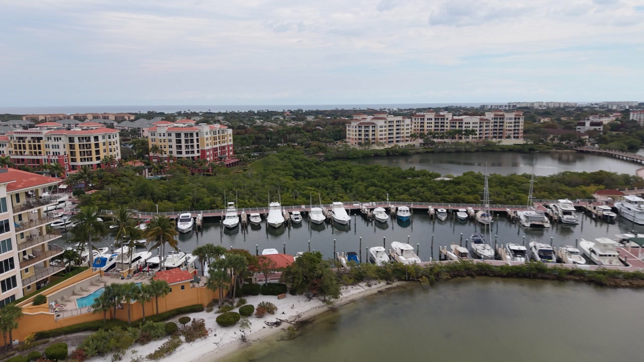 Drone flying over Intracoastal Waterway in Jupiter Florida near Waterway Park showing a large marina full of boats and waterfront condominiums.