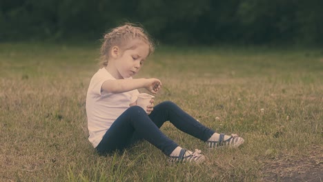 una chica linda come yogur descansando en el césped en el parque en cámara lenta